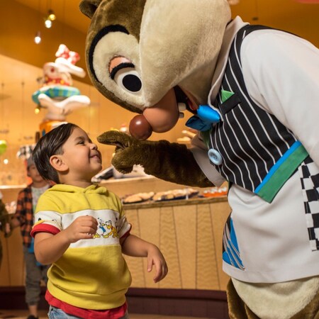Chip y Dale con un joven Visitante en Goofy's Kitchen en Disneyland Hotel