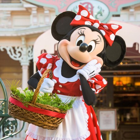 Minnie Mouse posa mientras sostiene una canasta frente a Plaza Inn