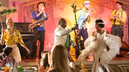 Guests dining in a Mardi Gras themed supper club with musicians and performers