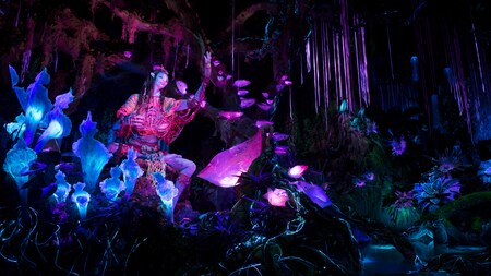 The Na’vi Shaman of Songs in a bioluminescent rainforest on the Na'vi River Journey attraction