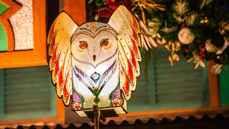 A large Christmas ornamental owl high over a street at the park