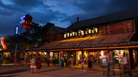 People stroll by House of Blues at Disney Springs in the evening