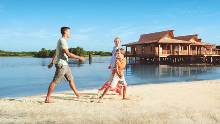 Une famille joyeuse marche sur la plage le long du Seven Seas Lagoon