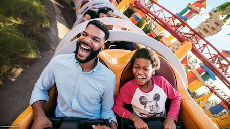 A boy and his father scream while riding Slinky Dog Dash in Toy Story Land	