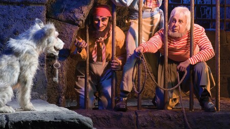Jailed outlaws try to lure a dog that holds a key in the Pirates of the Caribbean attraction 