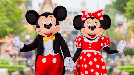 Mickey Mouse and Minnie Mouse pose, holding hands