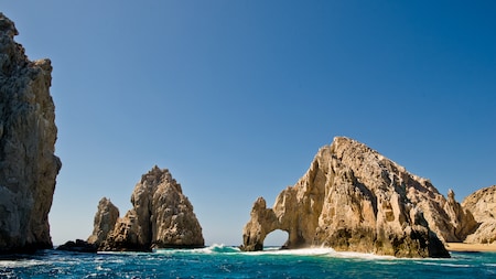 Two mountain shaped rock formations stand above the waves