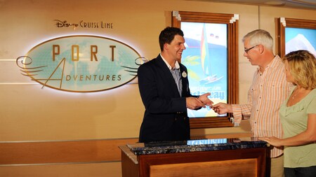 Un representante de Port Adventures ayuda a una pareja con su registro