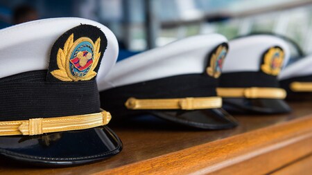 Captains' hats embroidered with the Disney Cruise Line logo sit in a row