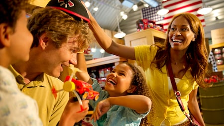 Una familia feliz se prueba sombreros en una tienda de mercancía de Disney