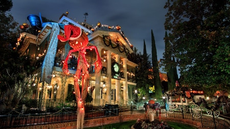 The Haunted Mansion decorated with holiday lights