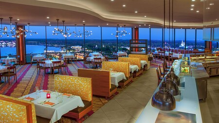 Interior of California Grill featuring booth, table and bar seating, floor to ceiling windows overlooking Walt Disney World Resort and more