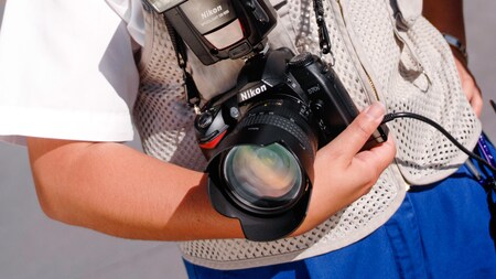 A camera with a large lens cradled in a Disney PhotoPass Photographer's arm