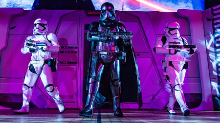 Captain Phasma holds her blaster rifle with an armed stormtrooper to either side