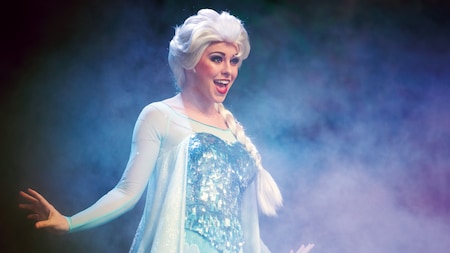 Elsa canta en un escenario oscuro durante For the First Time in Forever: A Frozen Sing-Along Celebration
