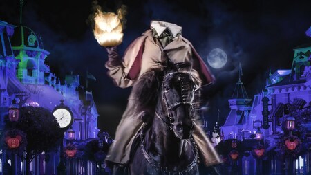 The Headless Horseman sitting on a on a horse and holding a fiery jack o lantern at night during Mickeys Not So Scary Halloween Party