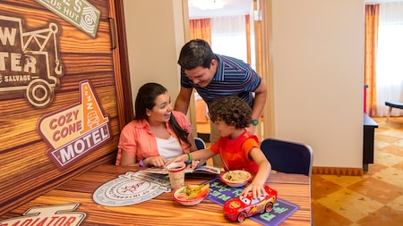 A mother, father and their young son enjoying breakfast together at Disney’s Art of Animation Resort