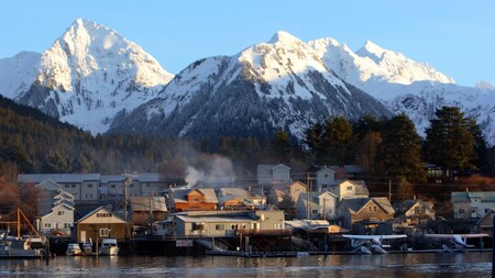 The city of Sitka, Alaska featuring snowcapped mountains and buildings along the water