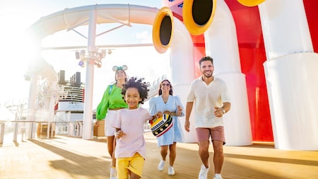 A family running on the upper deck of a Disney Cruise Line ship
