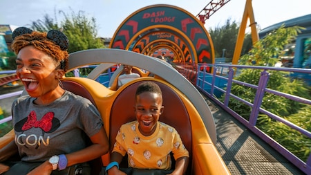 A mom wearing Mickey Mouse ears and her son scream while riding Slinky Dog Dash