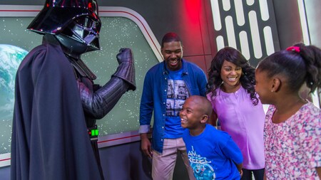 Darth Vader strikes a menacing pose while meeting a family of 4