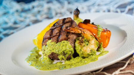 A surf and turf entrée featuring filet mignon, shrimp and chimichurri