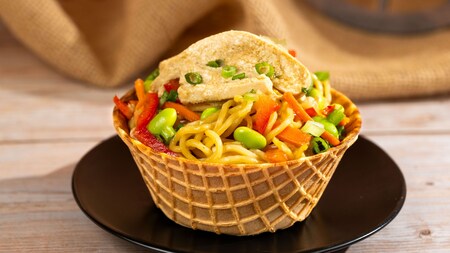 A waffle bowl of Plant based Soba Noodle Salad Bowl with edamame, peppers and carrots   