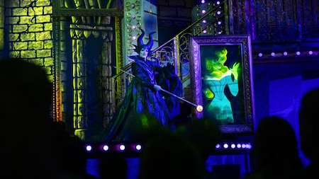Maleficent on stage with an animated portrait of Aurora during Disney Villains, Unfairly Ever After at Disney’s Hollywood Studios