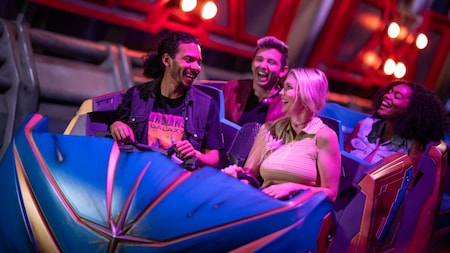 4 Guests talking while waiting to start their turn on the Guardians of the Galaxy Cosmic Rewind attraction