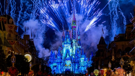 Fireworks explode above Cinderella Castle as the illuminated façade displays a Hades projection during Disney’s Not‑So‑Spooky Spectacular at Magic Kingdom.