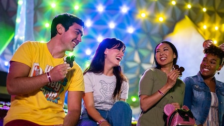 A group of friends laughing while enjoying Mickey Mouse ice cream bars