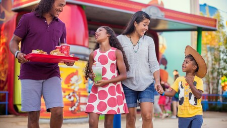Una familia de 4 personas cargan con su almuerzo por Toy Story Land en Disney’s Hollywood Studios