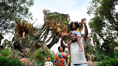 A father, mother and their 2 children walking under the floating mountains in Pandora The World of Avatar
