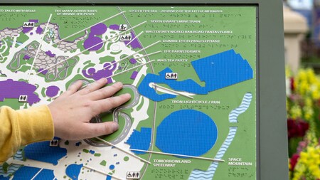 A guest uses a stationary braille map to explore the park.