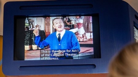 Video captions are displayed on a screen at the Carousel of Progress attraction.