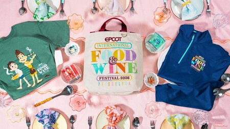 A decorated table featuring a shirt, tote bag and sweater from the Epcot International Food & Wine Festival 2026 Passholder merchandise collection