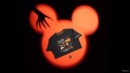 A Mickey's Not So Scary Halloween Party Passholder pin and shirt printed with ‘Boo to You’ artwork, displayed against a Mickey Mouse shaped shadow