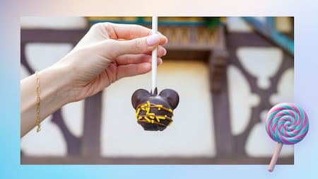 A hand holding a Mickey Mouse shaped cake pop