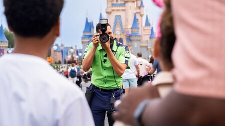 A Disney PhotoPass photographer taking a picture of a family