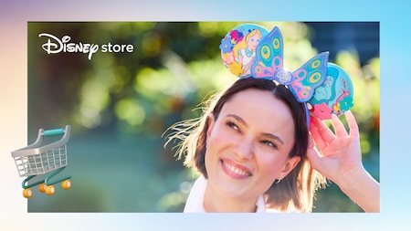 A smiling Guest wearing a Minnie Mouse ear headband, with the Disney store logo and a shopping cart icon