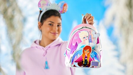  A Guest holds up a Frozen themed backpack from Loungefly featuring Anna and Elsa