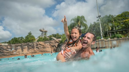 A father playing with his daughter in a pool at Disney's Typhoon Lagoon