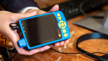 Un Miembro del Elenco muestra a un Visitante el Dispositivo Portátil de Disney 