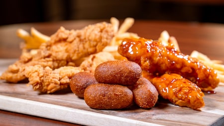 A plate of sauced and plain chicken fingers, corn dogs and fries from Stage Door Cafe