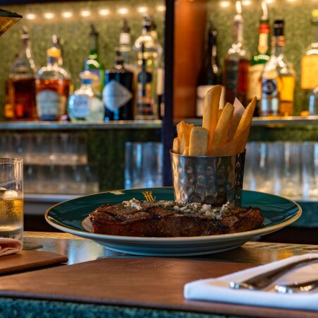A Slow Roasted Black Angus Prime Rib and french fries with a cocktail at Hearthstone Lounge