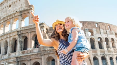イタリア、ローマのシンボルであるコロッセオの前に立つ女の子と手をつないだ母親
