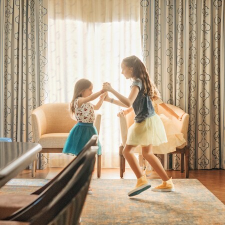 A woman and her 3 granddaughters on a bed, reading a bedtime story