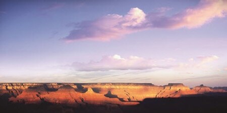 The mesas and striped walls of the Grand Canyon below a cloudy sky The mesas and striped walls of the Grand Canyon below a cloudy sky