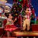 Minnie and Mickey wave to Guests while on a Christmas themed parade float
