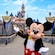 Mickey Mouse con los brazos extendidos frente al castillo Sleeping Beauty Castlee